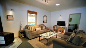 Una sala de estar con sofá, mesa de centro, televisor y chimenea.