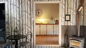 Una cocina acogedora con una mesa y sillas de madera, un reloj y un estufa de leña.