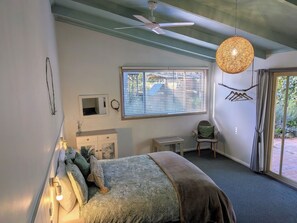 A bedroom with a bed, a desk, a chair, a window with blinds, a ceiling fan, and a hanging light fixture. - Kiwarrak Country Retreat (Koorainghat)