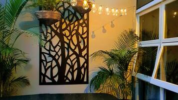 Relax in a stylish space with a geometric patterned wall, potted plants, and a large window.