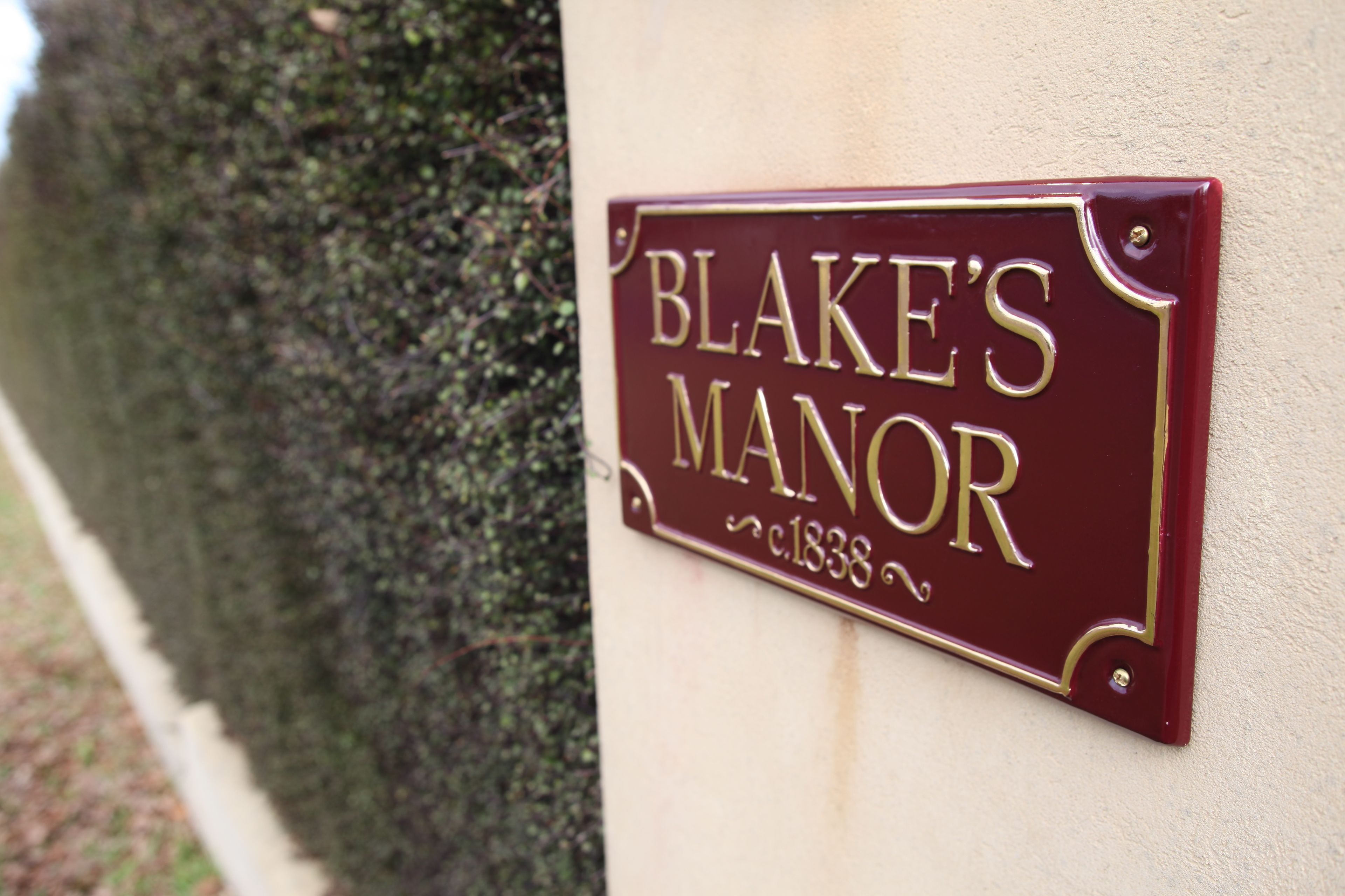 A house sign reading "BLAKE'S MANOR" with a date "c.1838".