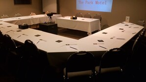A conference room with a long table, chairs, a projector screen displaying "Welcome The Park Motel", and a whiteboard. - The Park Motel (Hawera)
