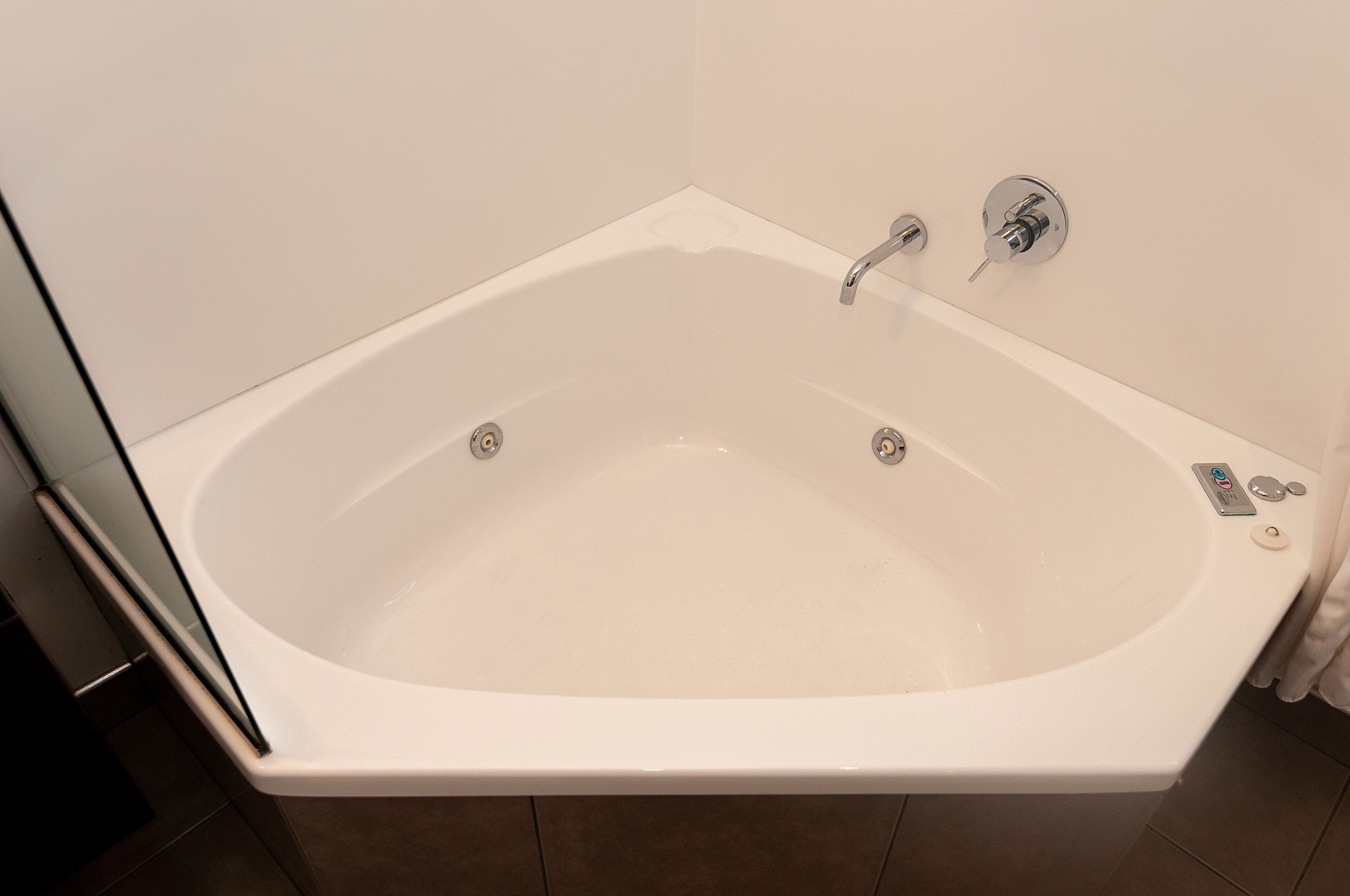 A white bathtub with a rectangular shape and a chrome faucet.