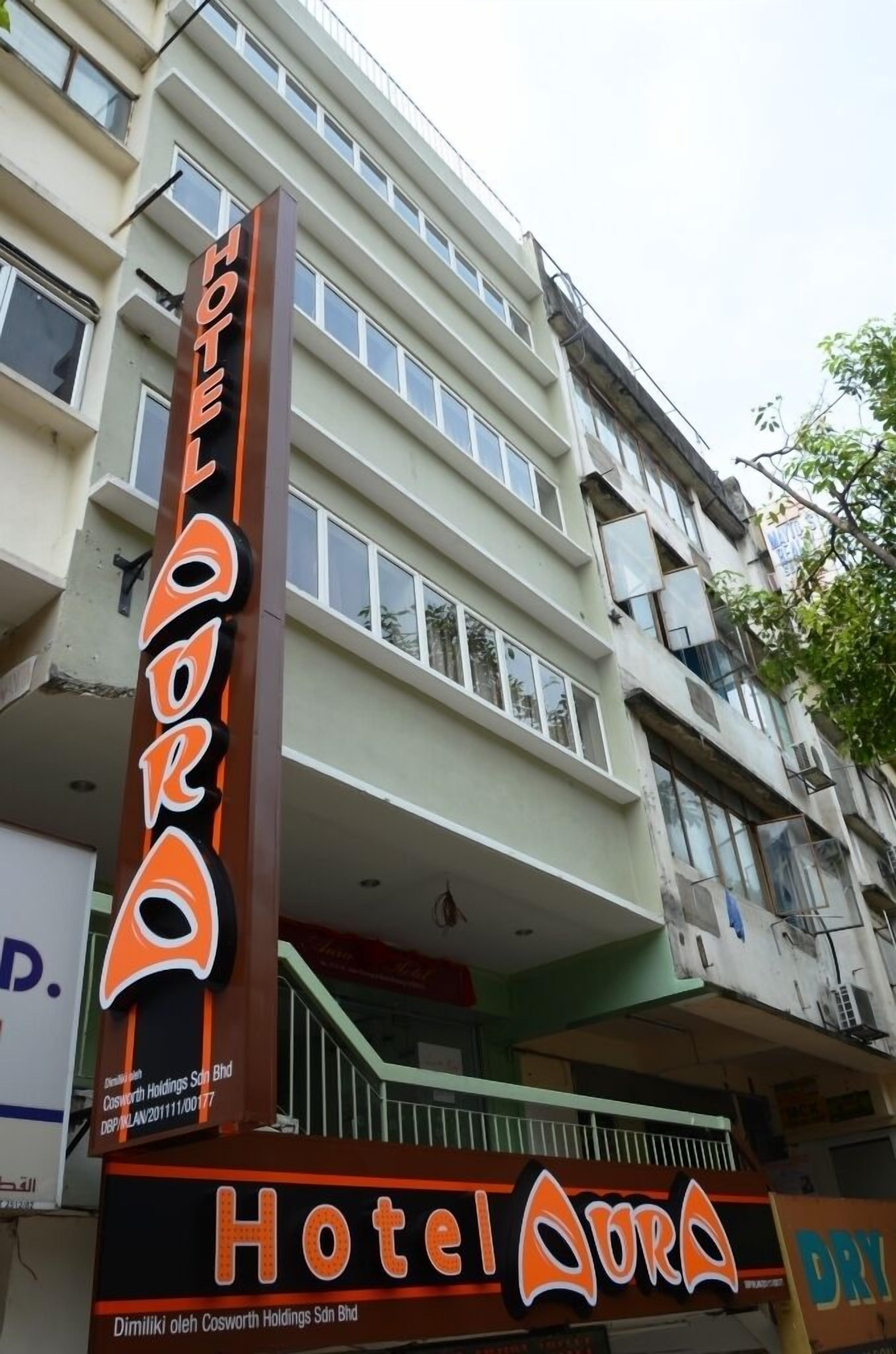 A multi-story building with a prominent sign for Hotel Aora.