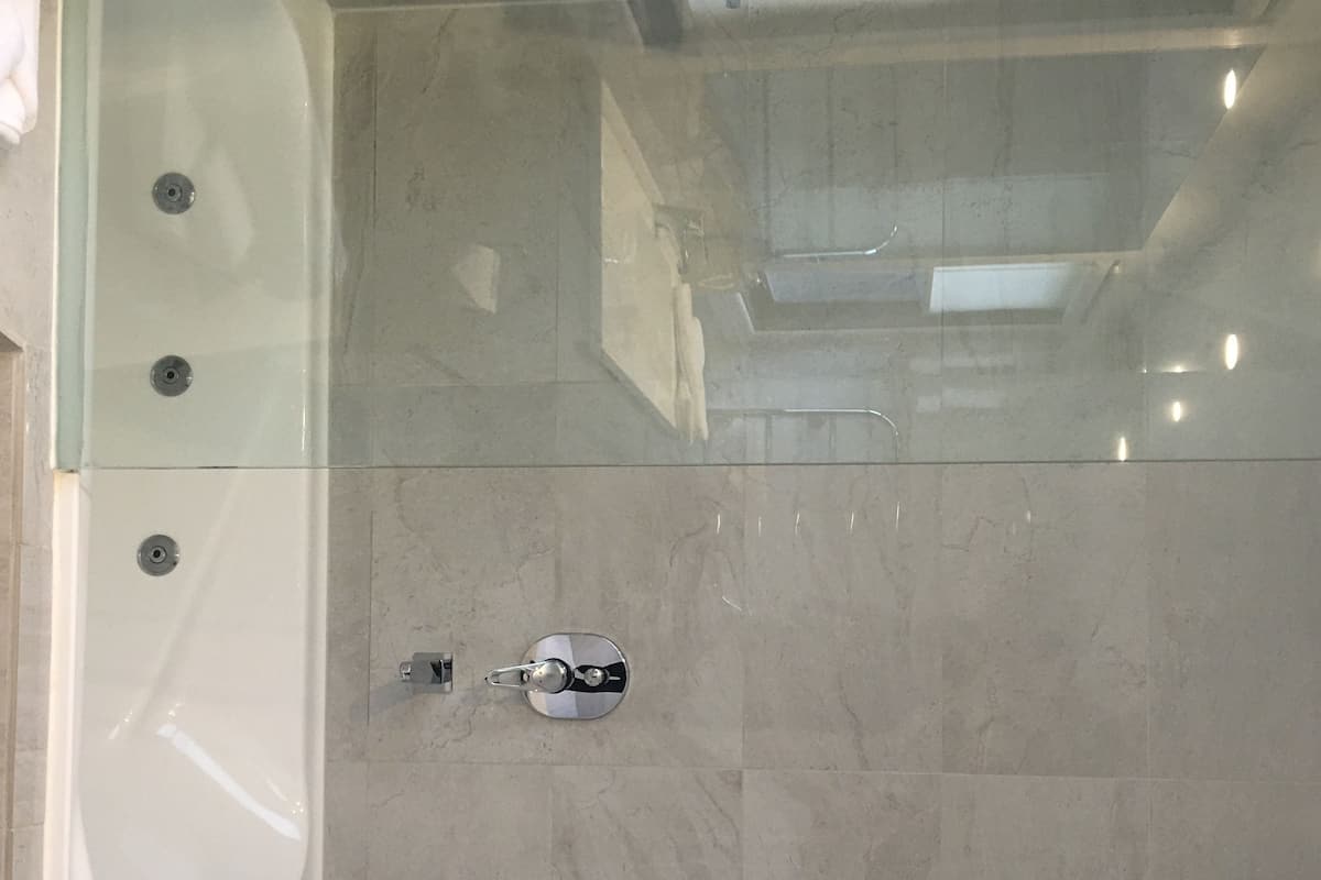 Une salle de bain moderne avec une douche à parois de verre, une baignoire et des toilettes.