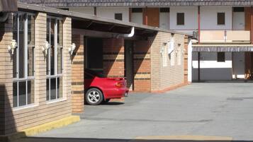 A building with a garage and a red car parked inside.