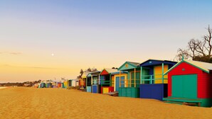 A row of colorful beach huts along a sandy beach. - Bayplay Beach Accommodation - 2 locations (Portsea)