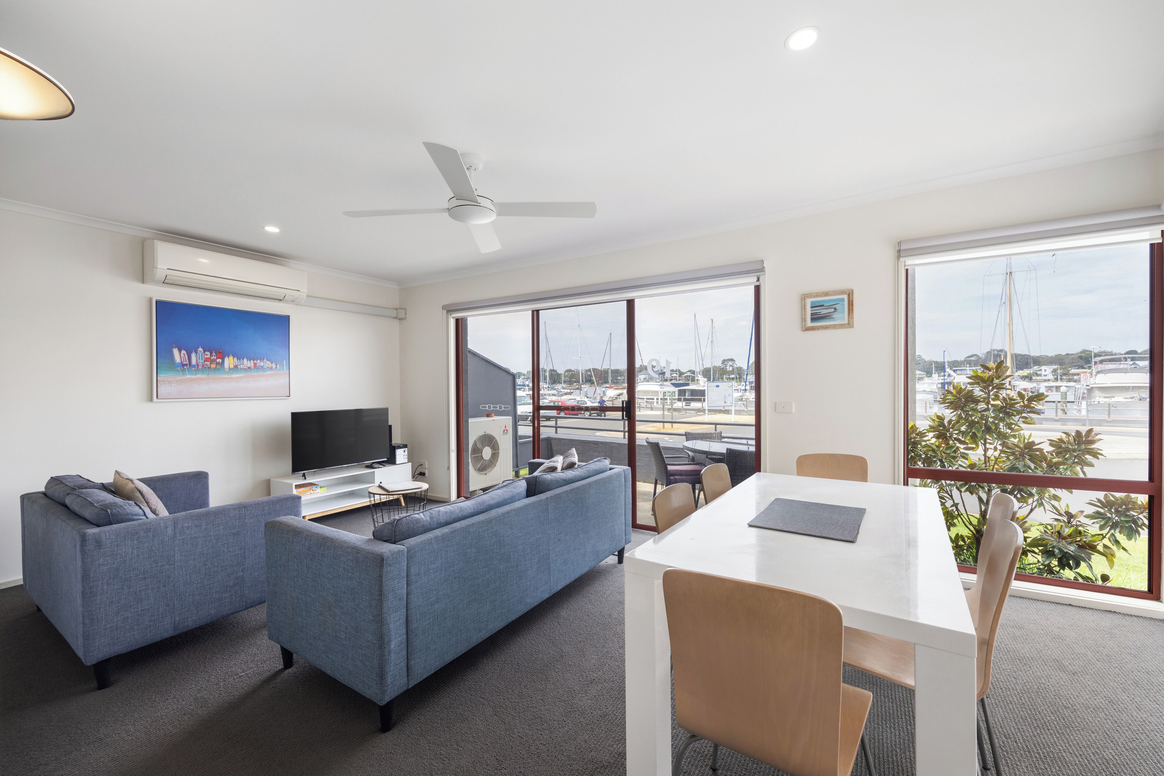 A modern living room with a sofa, TV, and dining area.
