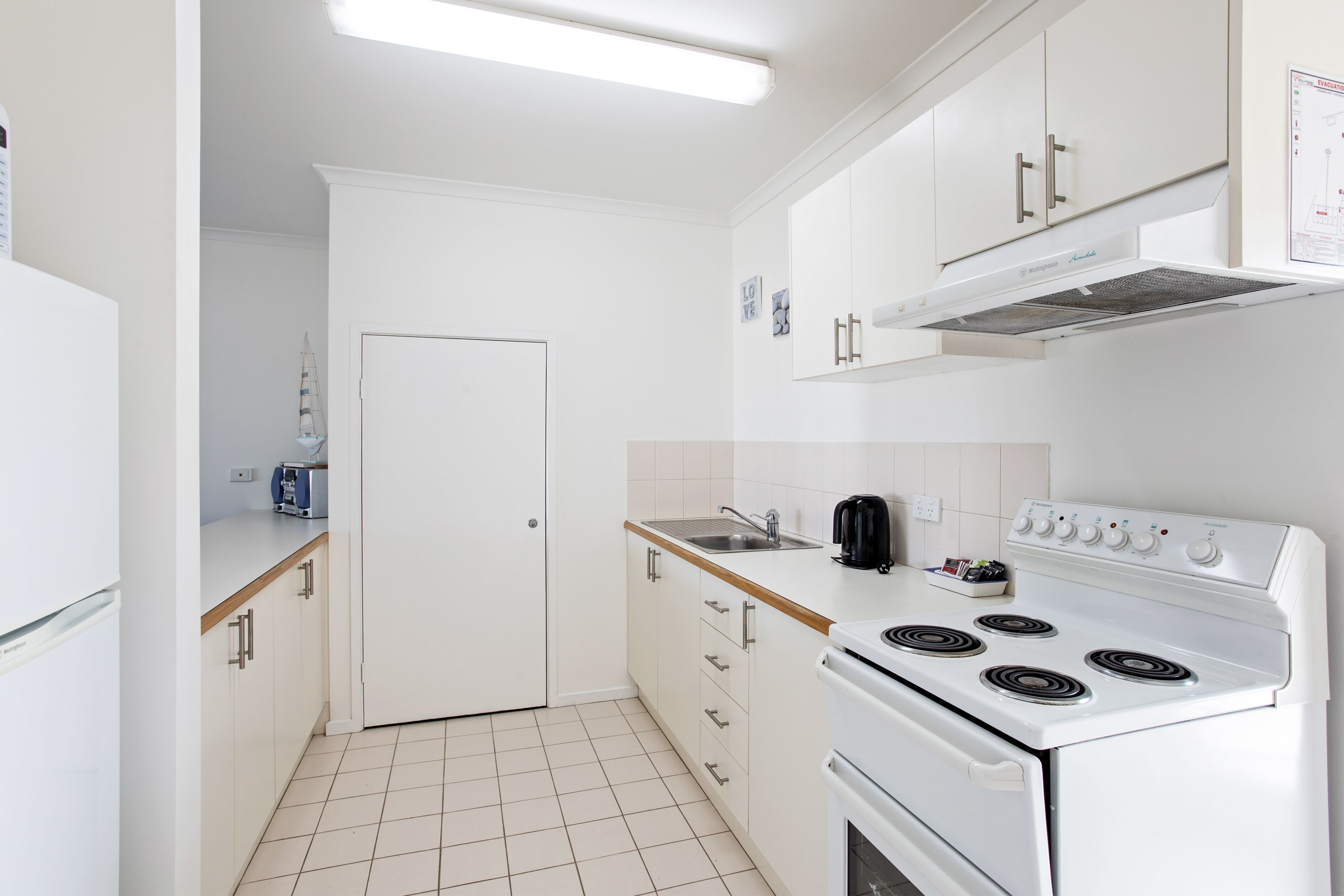 A modern kitchen with white cabinets, a stove, and a sink.