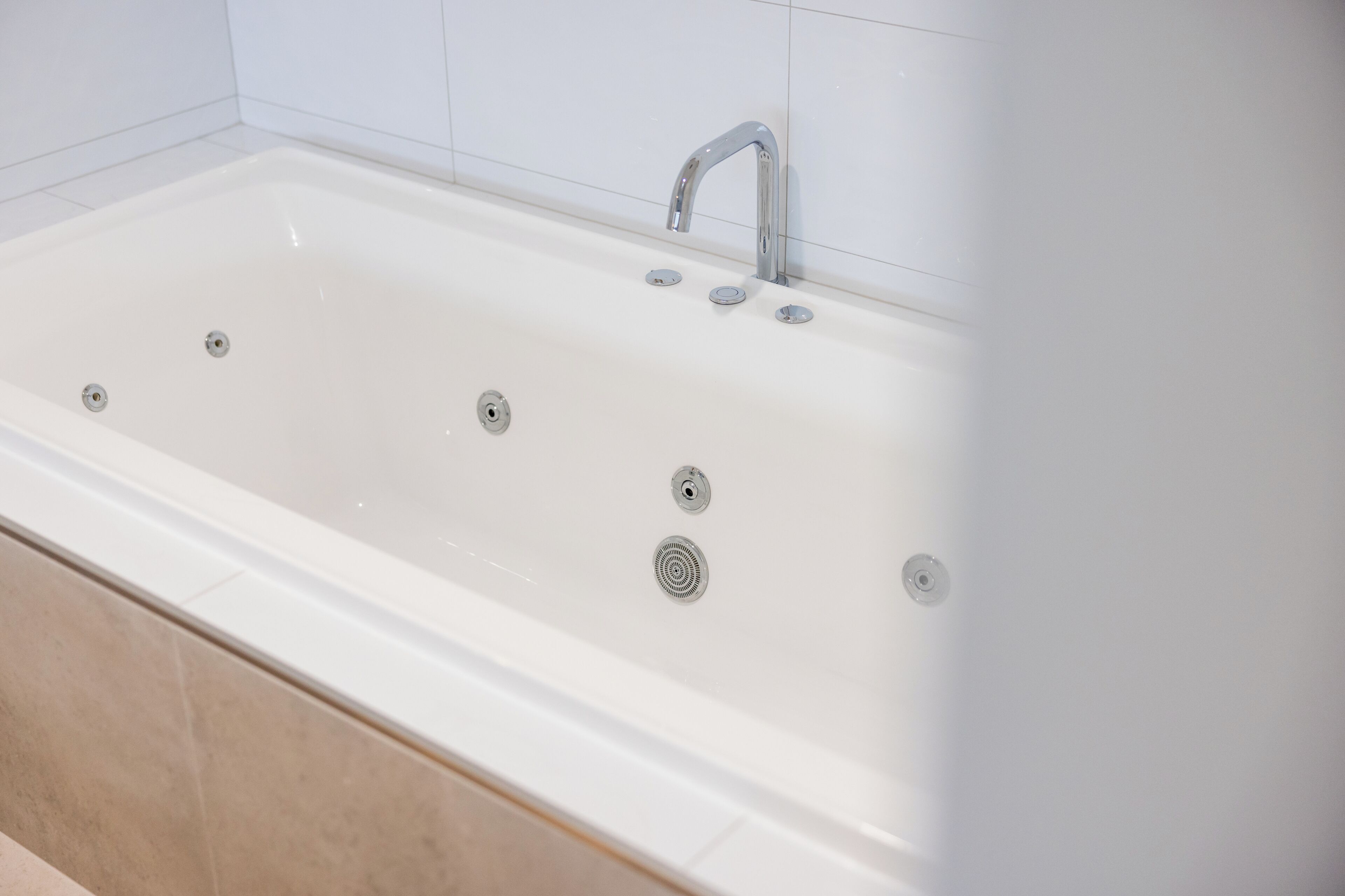 A white bathtub with a single faucet and three drain holes.