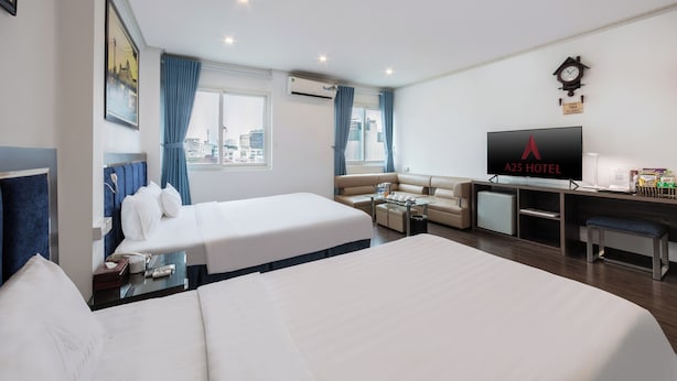 A hotel room with two beds, a sofa, a desk, and a television. - A25 Hotel - 45B Giang Vo (Hanoi)