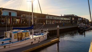 A waterfront marina with boats docked, a building with large windows, and a clear sky. - Point Lonsdale Holiday Apartments - Adults only (Point Lonsdale)