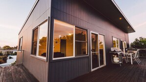 A modern house with large windows, a deck, and a grill area. - Point Lonsdale Holiday Apartments - Adults only (Point Lonsdale)