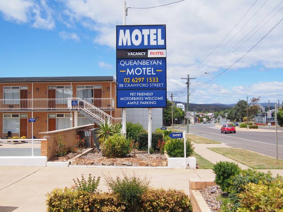 A motel sign with a no vacancy notice, contact number, and address.