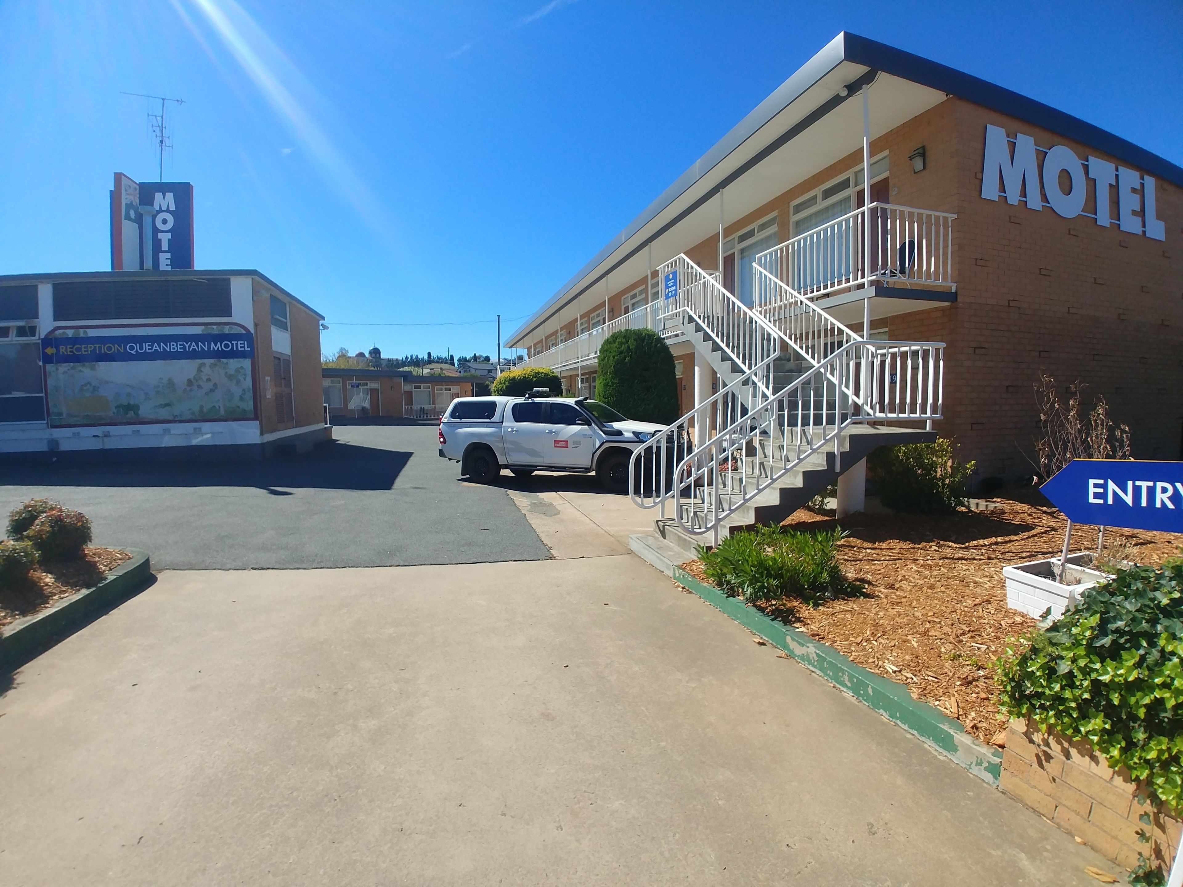 A motel with a reception area, a staircase leading to the entrance, and a parking lot.