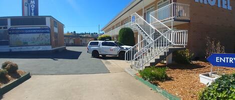 A motel with a reception area, a staircase leading to the entrance, and a parking lot.