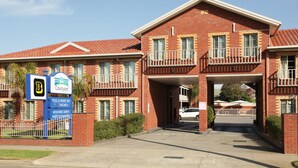 A brick building with a courtyard, a pool & heated spa, moderate tariffs, and an inspection notice.