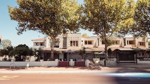 A building with a central courtyard, a covered seating area, and a bus stop. - The Civic Hotel (Inglewood)