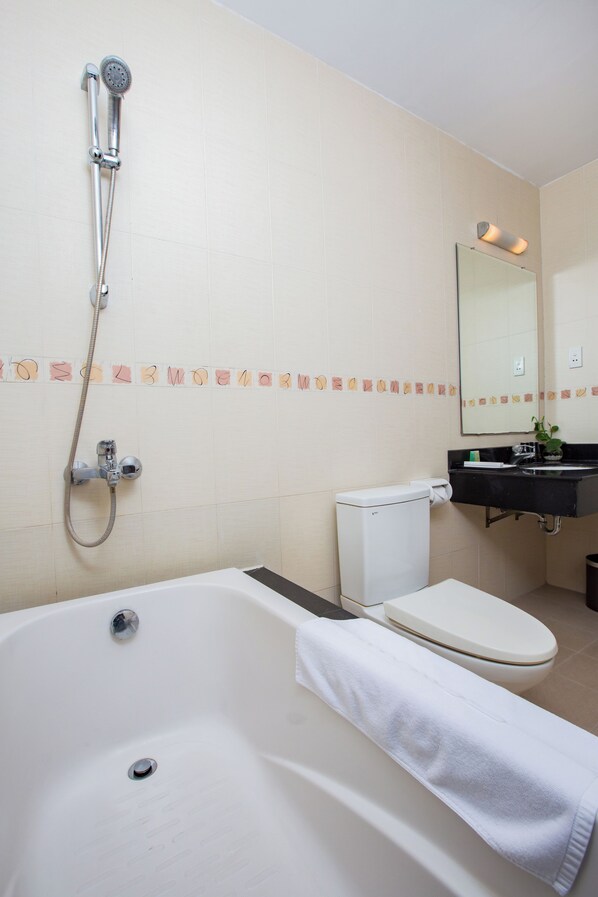 A bathroom with a bathtub, toilet, and shower.