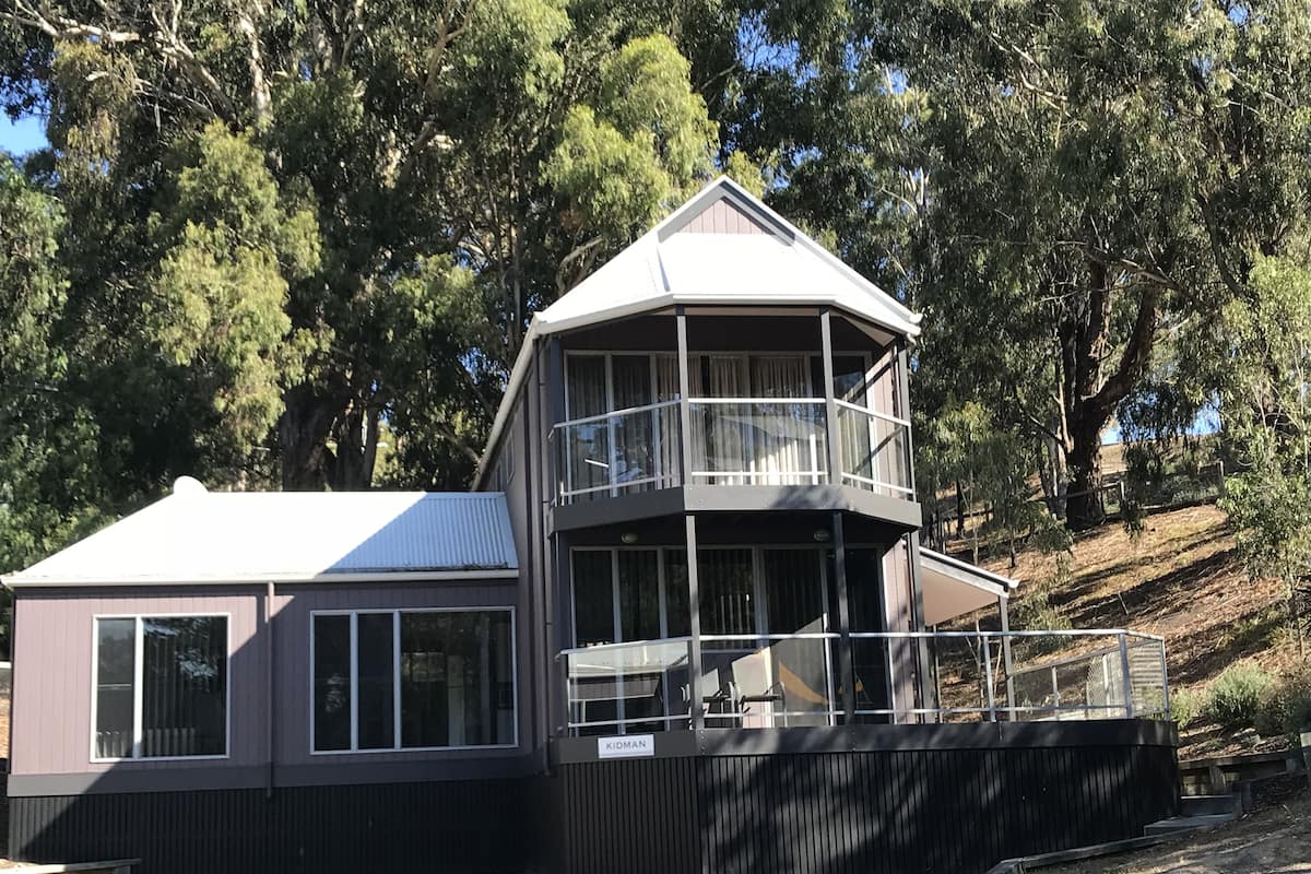 A modern two-story building with a balcony and a nameplate reading "KIDMAN".