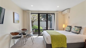 A bedroom with a bed, a desk, and chairs.
