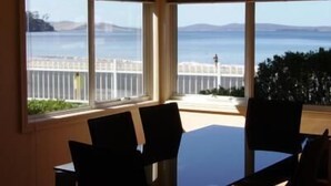 Una habitación con un amplio ventanal que ofrece vistas al mar y montañas distantes.