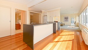 Una cocina moderna con una isla central, suelo de madera y vistas al área de estar.