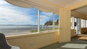 Una habitación con vistas al mar, una puerta blanca y una ventana que da a la calle.