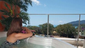 A person in a hot tub with a view of a mountainous landscape.