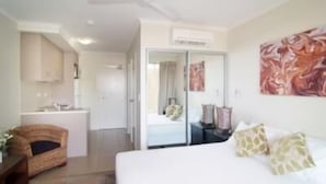 A hotel room with a bed, a desk, a chair, and a bathroom.