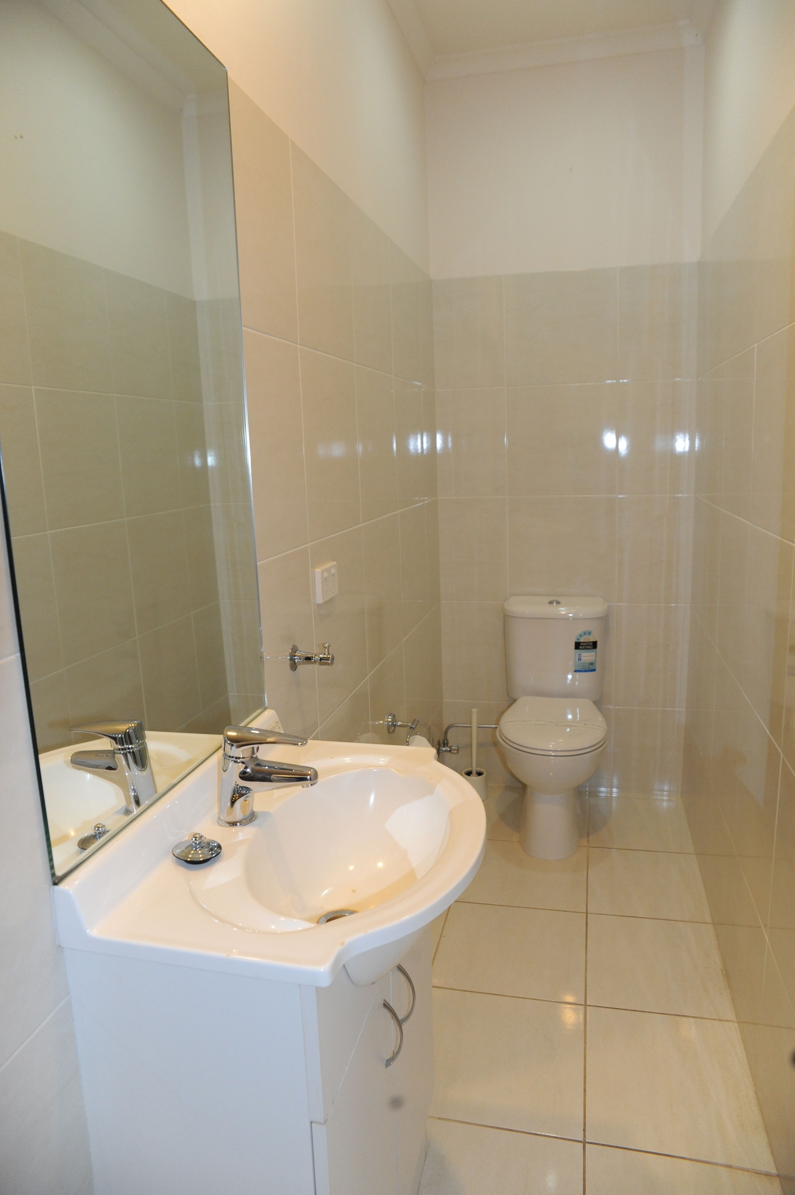 Ein Badezimmer mit einem weißen Waschbecken, Spiegel und WC.