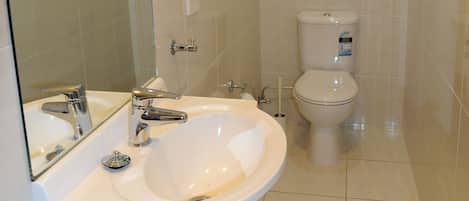 Ein Badezimmer mit einem weißen Waschbecken, Spiegel und WC.