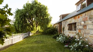 A stone building with a sloped roof and a small window. - Daisy Bank Cottages (Richmond)