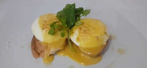 En rätt bestående av ägg benedicté med hollandaisesås och garnerad med persilja.