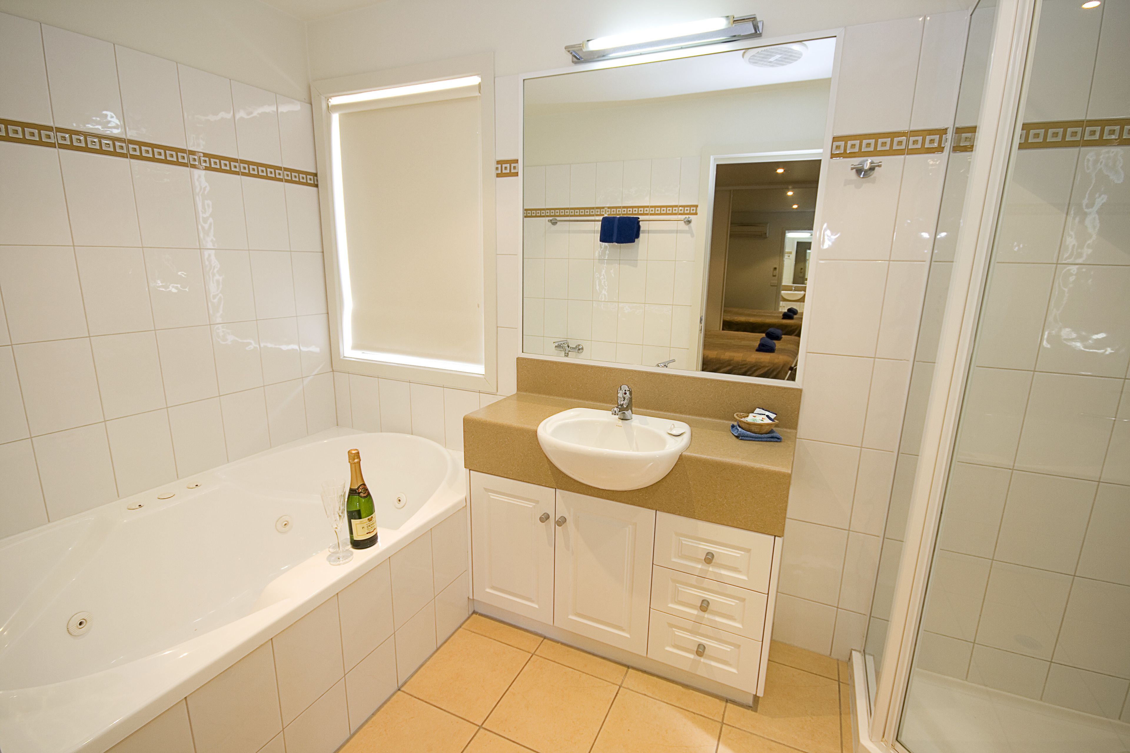 Une salle de bain moderne équipée d’une baignoire, d’un lavabo, d’un miroir et d’une douche.