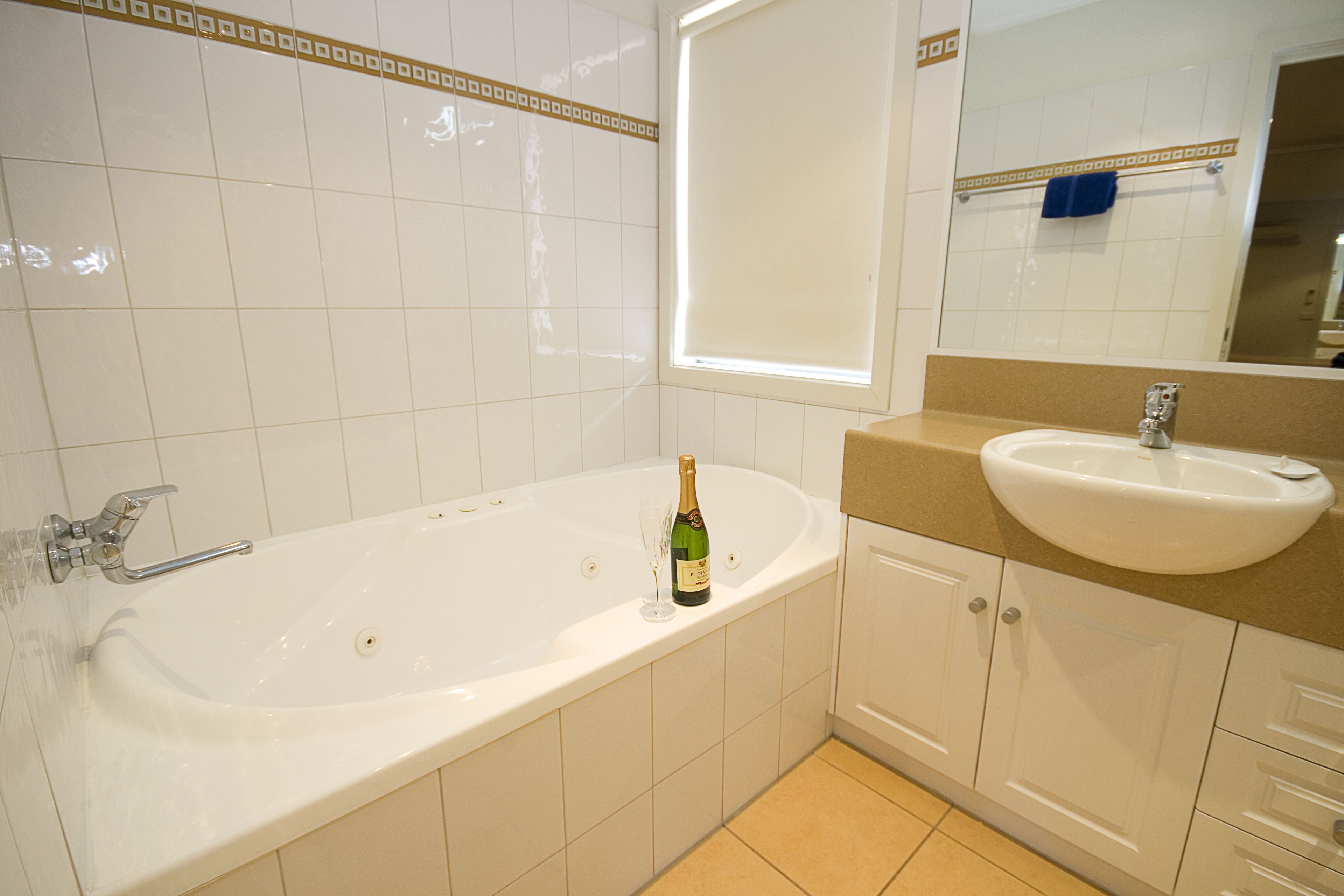Un baño con bañera, lavamanos y espejo.