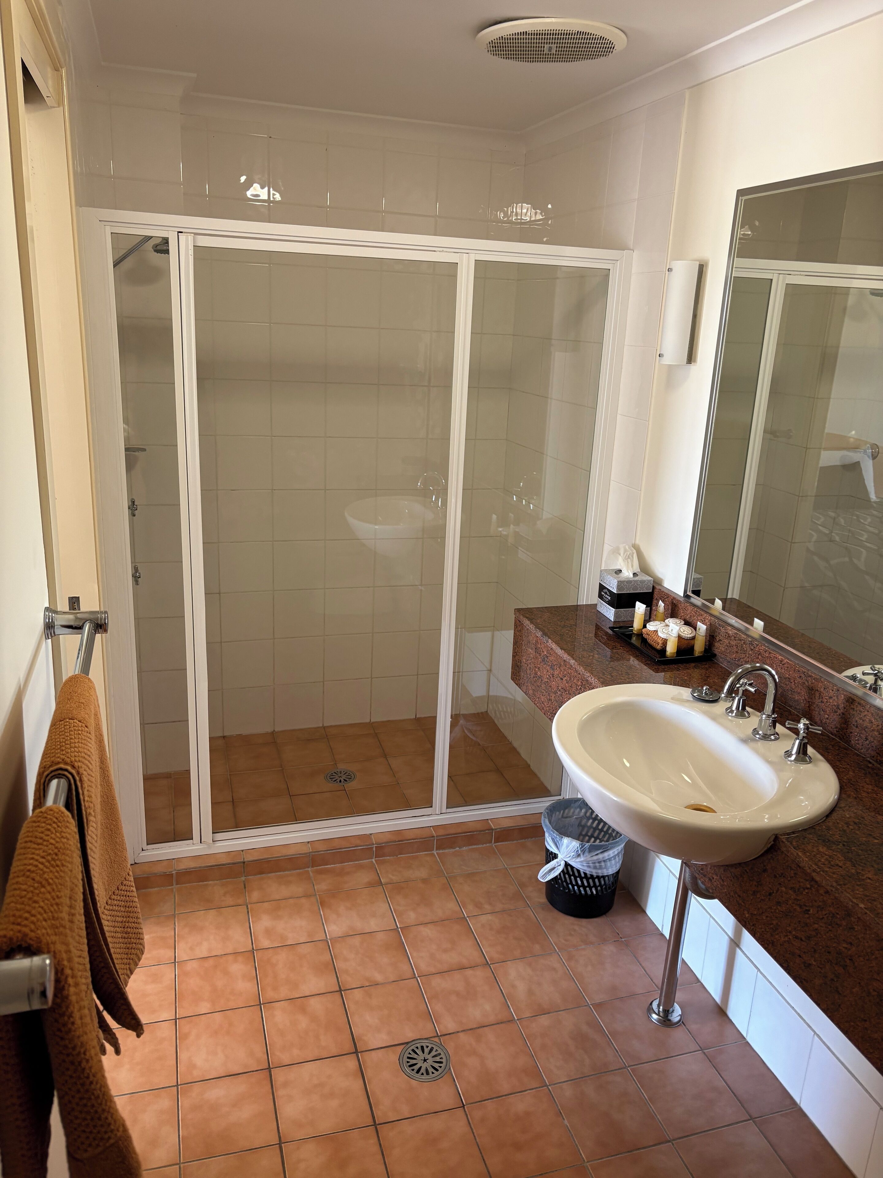 Un baño con cabina de ducha, lavabo y espejo.