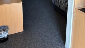 A hotel room with a desk, a small table, a sofa, and a bed. - Golden Guitar Motor Inn (Hillvue)