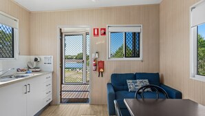 Habitación compacta con kitchenette, sofá, mesa de comedor y ventana con vistas.