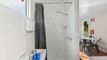 Un baño moderno con ducha, inodoro y lavamanos con artículos de aseo.