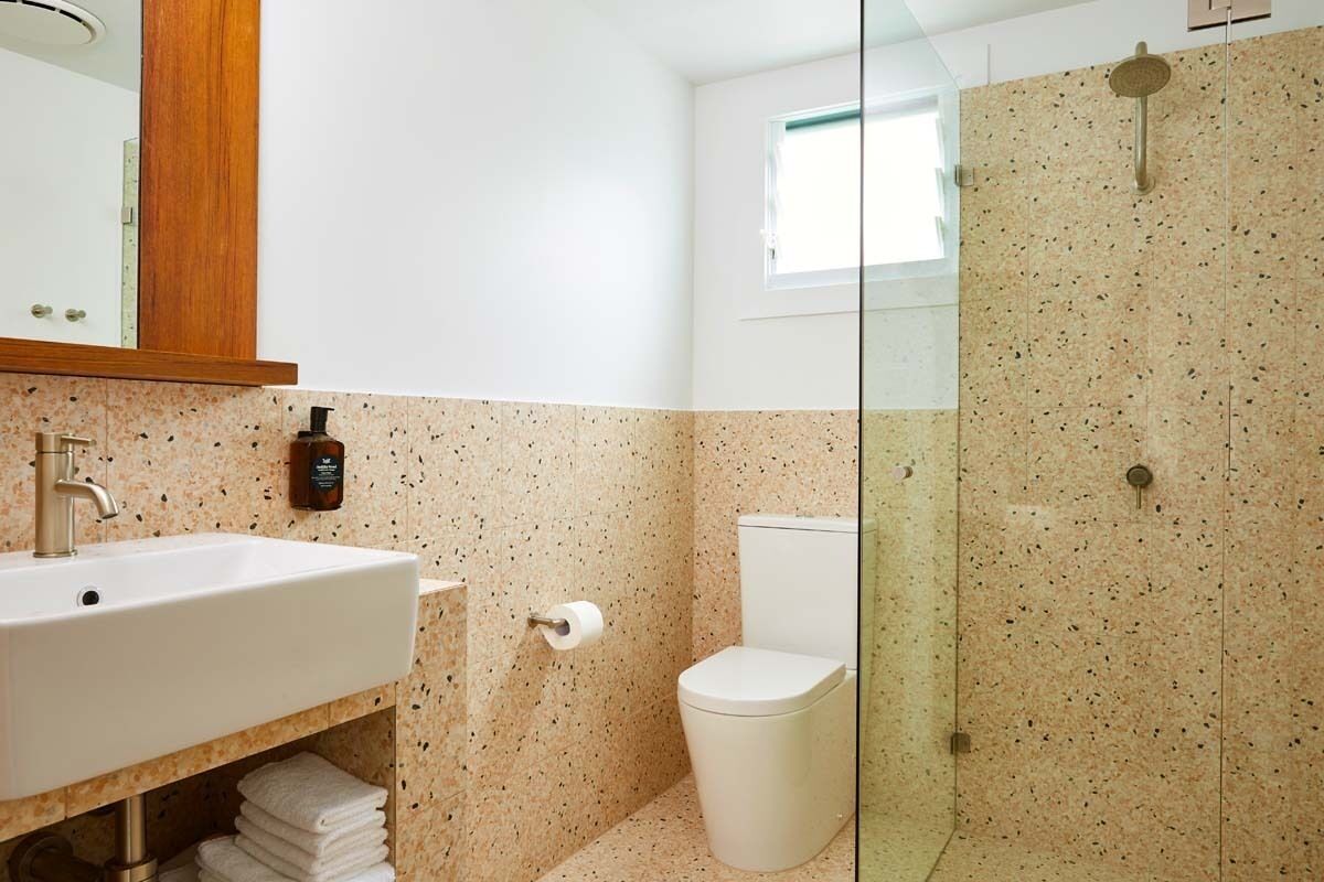 A bathroom with a white sink, a toilet, and a glass-enclosed shower.