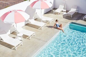 A poolside area with lounge chairs and umbrellas. - The Sails Motel Brunswick Heads (Brunswick Heads)