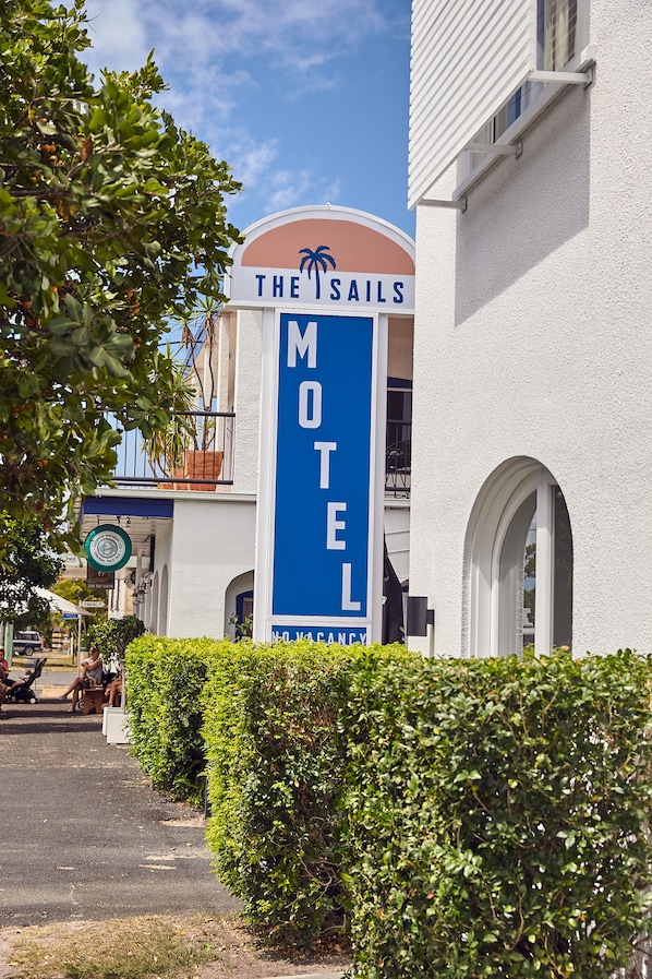 A motel sign with a palm tree logo, indicating a tropical theme. - The Sails Motel Brunswick Heads (Brunswick Heads)