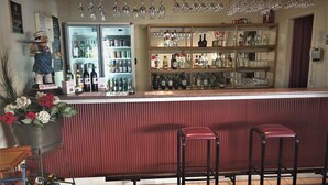 A bar area with a refrigerated display case, shelves with bottles, and stools. - Ceduna Motor Inn (Ceduna)