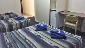 A hotel room with two beds, a desk, and a chair.