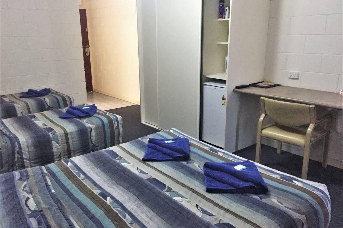 Una habitación de hotel con dos camas, un escritorio y una silla.