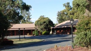 A building with a covered entrance and a landscaped driveway. - Sportslander Motor Inn (Moama)