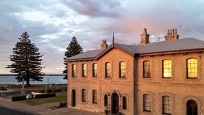 A large, two-story building with a symmetrical facade, multiple windows, and a prominent chimney. - The Customs House Port MacDonnell (Port Macdonnell)