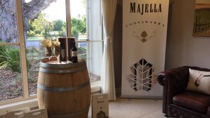 Una habitación con un barril de madera grande, un sofá de cuero y un cartel en la pared que dice "MAJELLA COONAWARRA".
