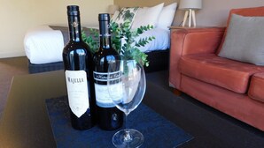 Dos botellas de vino y una copa sobre una mesa en una habitación de hotel.